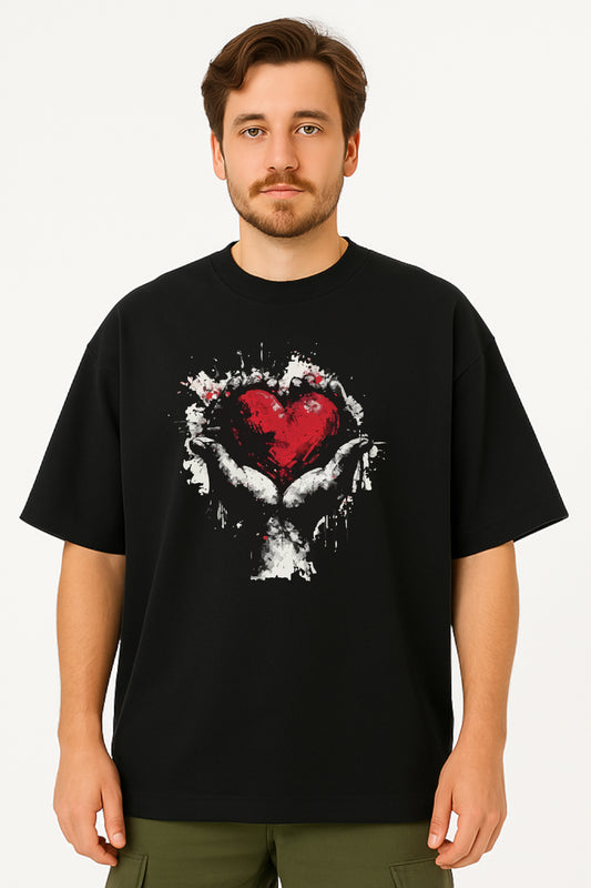 Man wearing a black t-shirt with a graphic design of a heart and hands on a white background