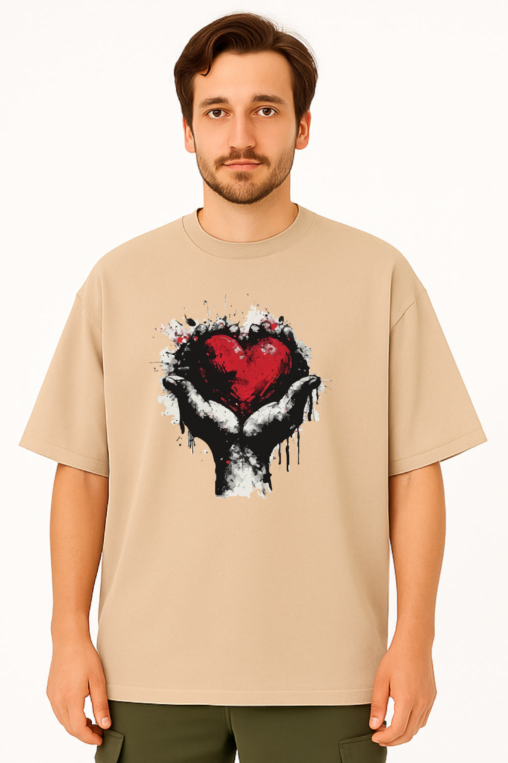 Man wearing a beige t-shirt with a graphic design of a hand holding a heart.