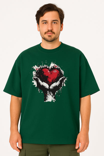 Man wearing a green t-shirt with a graphic design of a heart and hands on a white background