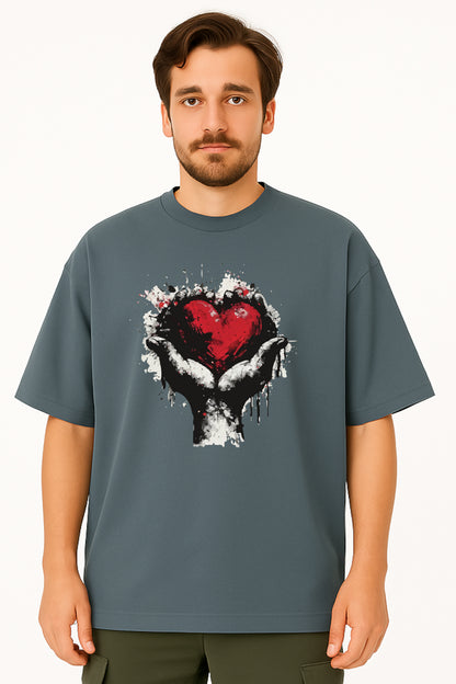 Man wearing a gray t-shirt with a graphic design of a heart and hands on a white background